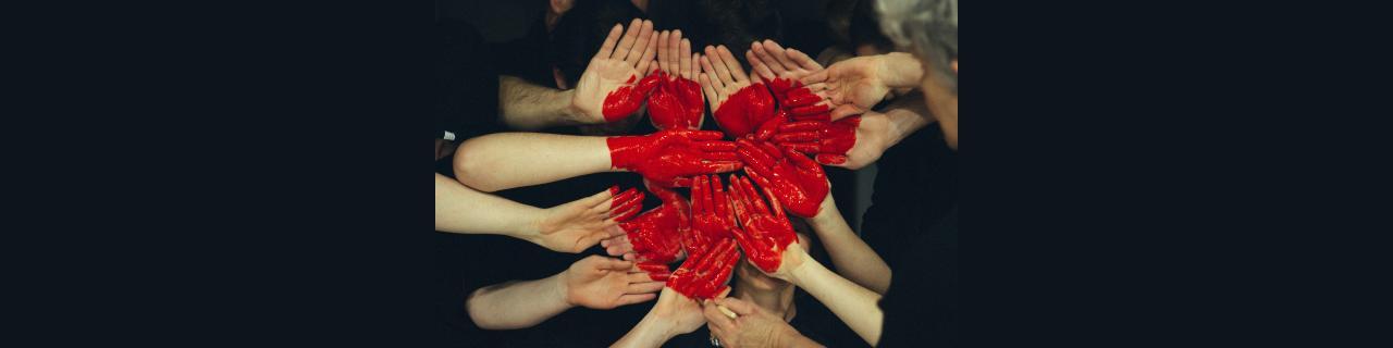 Many hands with red painted heart